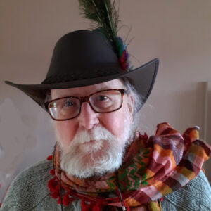 photo of Jeff Merrifield, an older man with a beard, wearing a hat with a feather in